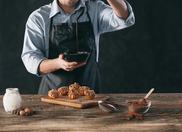 decorating-delicious-homemade-eclairs-with-chocolate-peanuts